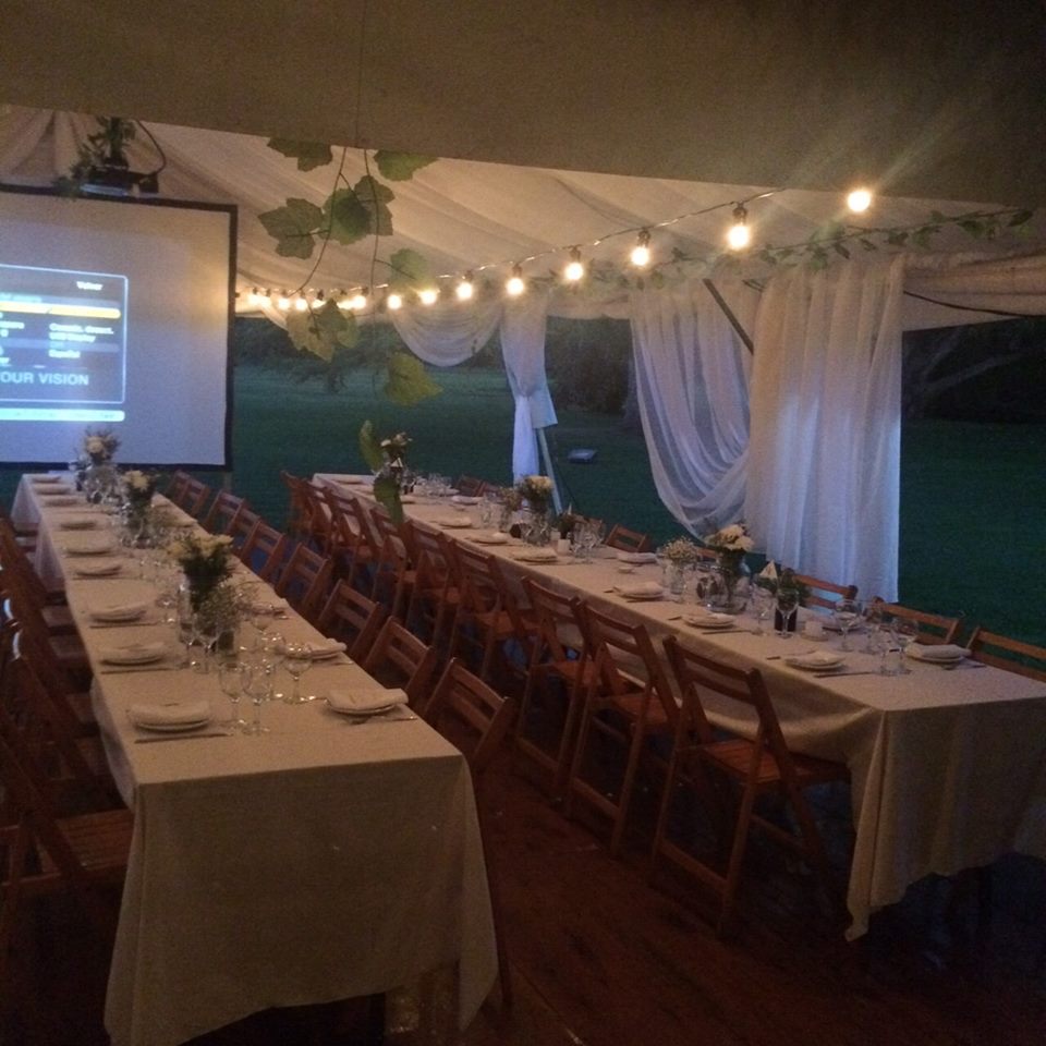 Mesa larga con luces cálidas bajo carpa